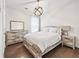 Bedroom with light wooden furniture, dark wood floors and stylish overhead light fixture at 310 Braeden Way, Alpharetta, GA 30009
