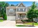 Charming two-story home with gray siding, white trim, front porch, attached two-car garage, and nicely landscaped front yard at 310 Braeden Way, Alpharetta, GA 30009