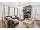 Stylish living room with a stone fireplace, large sectional sofa, and modern lighting fixtures at 310 Braeden Way, Alpharetta, GA 30009