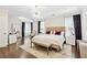 Elegant main bedroom suite with statement chandelier, sitting area, and large windows at 310 Braeden Way, Alpharetta, GA 30009