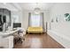 Functional office space with bright yellow sofa, streamlined furniture, and warm hardwood flooring at 310 Braeden Way, Alpharetta, GA 30009