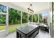 Screened-in porch with ping pong table and view of backyard greenery at 310 Braeden Way, Alpharetta, GA 30009