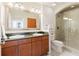 Bathroom featuring dual sinks, wooden cabinets, and a glass-enclosed shower at 3445 Stratford Ne Rd # 2409, Atlanta, GA 30326