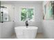 Modern bathroom featuring a soaking tub, separate shower, and bright natural light at 528 Pumpkinvine Rd, Acworth, GA 30101