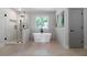 Modern bathroom featuring a glass-enclosed shower, soaking tub, and neutral-colored walls at 528 Pumpkinvine Rd, Acworth, GA 30101