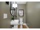 Stylish powder room with pedestal sink, unique mirror, and neutral color palette at 528 Pumpkinvine Rd, Acworth, GA 30101
