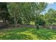 Lush backyard showcasing a well-manicured lawn with mature trees and a privacy fence at 6755 Waveland Dr, Cumming, GA 30040