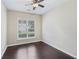 Well-lit bedroom featuring a ceiling fan, window with plantation shutters, and sleek hardwood floors at 6755 Waveland Dr, Cumming, GA 30040