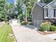 View of back of the house with a detached garage, spacious driveway, and lush landscaping at 70 Maplewood Ln, Acworth, GA 30101