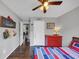 Comfortable bedroom with hardwood floors, a ceiling fan, and a cozy red, white, and blue bed at 70 Maplewood Ln, Acworth, GA 30101