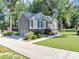 Side view of the home with garage, basketball hoop, lush landscaping and green lawn at 70 Maplewood Ln, Acworth, GA 30101