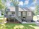 Back exterior view showcasing a spacious deck, well-maintained lawn, and lush landscaping at 70 Maplewood Ln, Acworth, GA 30101