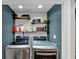 Well-organized laundry room with modern washer and dryer, shelves, and decorative touches at 70 Maplewood Ln, Acworth, GA 30101
