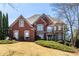 Charming brick two-story home with a well-manicured lawn and mature trees at 1037 Windermere Xing, Cumming, GA 30041