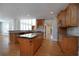 Open kitchen with wood cabinets, an island with granite countertop, and modern stainless steel appliances at 1037 Windermere Xing, Cumming, GA 30041