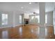 Bright, airy living room showcasing a stone fireplace, hardwood floors, and large windows with shutters at 1037 Windermere Xing, Cumming, GA 30041
