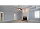 Bright living room showcasing a fireplace, ceiling fan and neutral colored carpet at 1037 Windermere Xing, Cumming, GA 30041