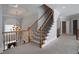 Elegant staircase with wood and iron railing leading to a second floor landing with neutral colored carpet at 1037 Windermere Xing, Cumming, GA 30041