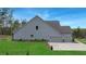 Exterior view showing a three-car garage with a well-maintained lawn and landscaping at 174 Vandiver Ct, Acworth, GA 30101