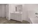 Contemporary bathroom featuring double vanity, tiled floor, and bathtub with tiled backsplash at 1821 Lacebark Elm Way, Lawrenceville, GA 30045