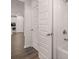 En suite bathroom with wood floors, walk in tub, and access to hallway and kitchen at 1821 Lacebark Elm Way, Lawrenceville, GA 30045