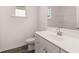 Clean bathroom featuring a bright window, wood look flooring, and a white vanity with a large sink at 1821 Lacebark Elm Way, Lawrenceville, GA 30045