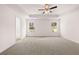 Spacious bedroom featuring plush carpeting, tray ceiling and modern ceiling fan, and natural light from two windows at 1821 Lacebark Elm Way, Lawrenceville, GA 30045