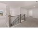 Hallway boasts neutral-toned walls and carpet, complemented by wood and black iron railing on the staircase at 1821 Lacebark Elm Way, Lawrenceville, GA 30045