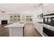 Open-concept kitchen with stainless steel appliances, a center island, and seamless flow into the living area at 1821 Lacebark Elm Way, Lawrenceville, GA 30045