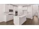 Elegant kitchen showcasing white cabinets, stainless steel appliances, a center island, and hardwood flooring at 1821 Lacebark Elm Way, Lawrenceville, GA 30045