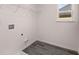 Bright laundry room featuring gray tile flooring, utility connections, and wire shelving storage at 1821 Lacebark Elm Way, Lawrenceville, GA 30045