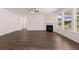 Open living room with a fireplace, hardwood floors, and large windows offering backyard views at 1821 Lacebark Elm Way, Lawrenceville, GA 30045