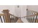 View looking down the staircase with wood and black iron railing leading to the entryway with chandelier at 1821 Lacebark Elm Way, Lawrenceville, GA 30045
