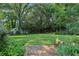 Lush backyard with mature trees, a swing, and a stone patio, ideal for relaxation and outdoor enjoyment at 5623 Crestwood Dr, Stone Mountain, GA 30087