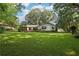 Expansive backyard with lush green lawn and the rear exterior of the home at 5623 Crestwood Dr, Stone Mountain, GA 30087