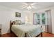 Bright bedroom featuring a ceiling fan, hardwood floors, a window with curtains, and neutral paint at 5623 Crestwood Dr, Stone Mountain, GA 30087
