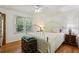 Bright bedroom featuring hardwood floors, a ceiling fan, and a large window with wooded views at 5623 Crestwood Dr, Stone Mountain, GA 30087