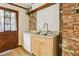 Compact kitchen with stainless steel sink and brick accents, next to side entrance at 5623 Crestwood Dr, Stone Mountain, GA 30087