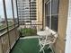 Balcony featuring artificial grass, a white table and chairs set, and views of the surrounding buildings at 300 Peachtree St # Apt 9D, Atlanta, GA 30308