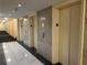 Hallway with several elevators, marble flooring, and neutral-toned walls with room numbers on the doors at 300 Peachtree St # Apt 9D, Atlanta, GA 30308