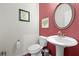 Stylish powder room with pedestal sink, round mirror, and decorative accents at 4554 Grenadine Cir, Acworth, GA 30101