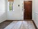 Inviting foyer featuring a dark wood door, decorative rug, and classic wainscoting at 4554 Grenadine Cir, Acworth, GA 30101