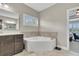 Bathroom showcases a corner soaking tub, sleek vanity, and window with stylish shutters at 521 Andes Ln, Canton, GA 30114