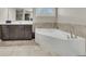 Stylish bathroom features a soaking tub, a vanity with ample storage, and neutral tile flooring at 521 Andes Ln, Canton, GA 30114