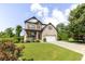 Lovely two-story home with manicured lawn, brick and stone detailing, and a spacious driveway leading to an attached garage at 521 Andes Ln, Canton, GA 30114