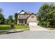 Inviting two-story home with manicured lawn, charming porch with rocking chairs, and a blend of brick and stone accents at 521 Andes Ln, Canton, GA 30114