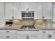Modern kitchen with stainless steel appliances, white cabinetry, and granite countertops at 521 Andes Ln, Canton, GA 30114