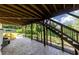 Covered patio with gray pavers and stairs to a deck with a view of the backyard and wooded area at 521 Andes Ln, Canton, GA 30114