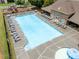 Aerial view of a large pool with lounge chairs, kiddie pool with mushroom fountain, tables, and a nearby playground at 521 Andes Ln, Canton, GA 30114