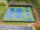 Aerial view of well maintained blue and green tennis and pickleball courts surrounded by mature trees in a gated community at 521 Andes Ln, Canton, GA 30114